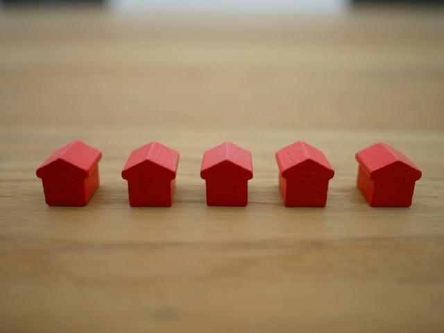 a bunch of red house figurines in a row