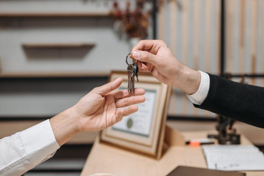 one person handing keys to another